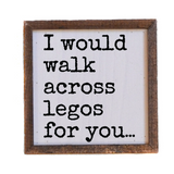 Wooden sign with text 'I would walk across legos for you...' on a white background