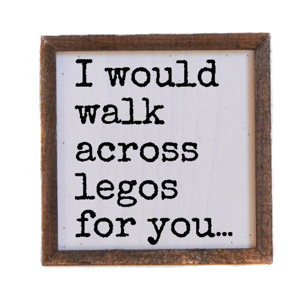 Wooden sign with text 'I would walk across legos for you...' on a white background